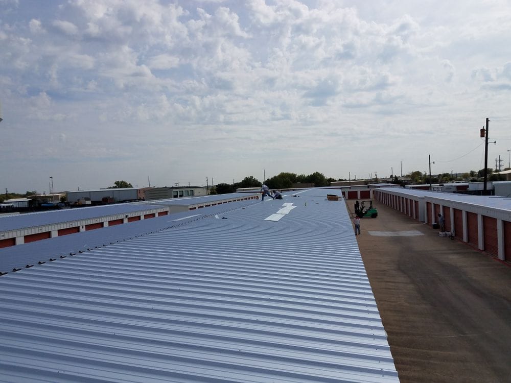 DT Roofing team in action, installing a new roof on a commercial storage unit
